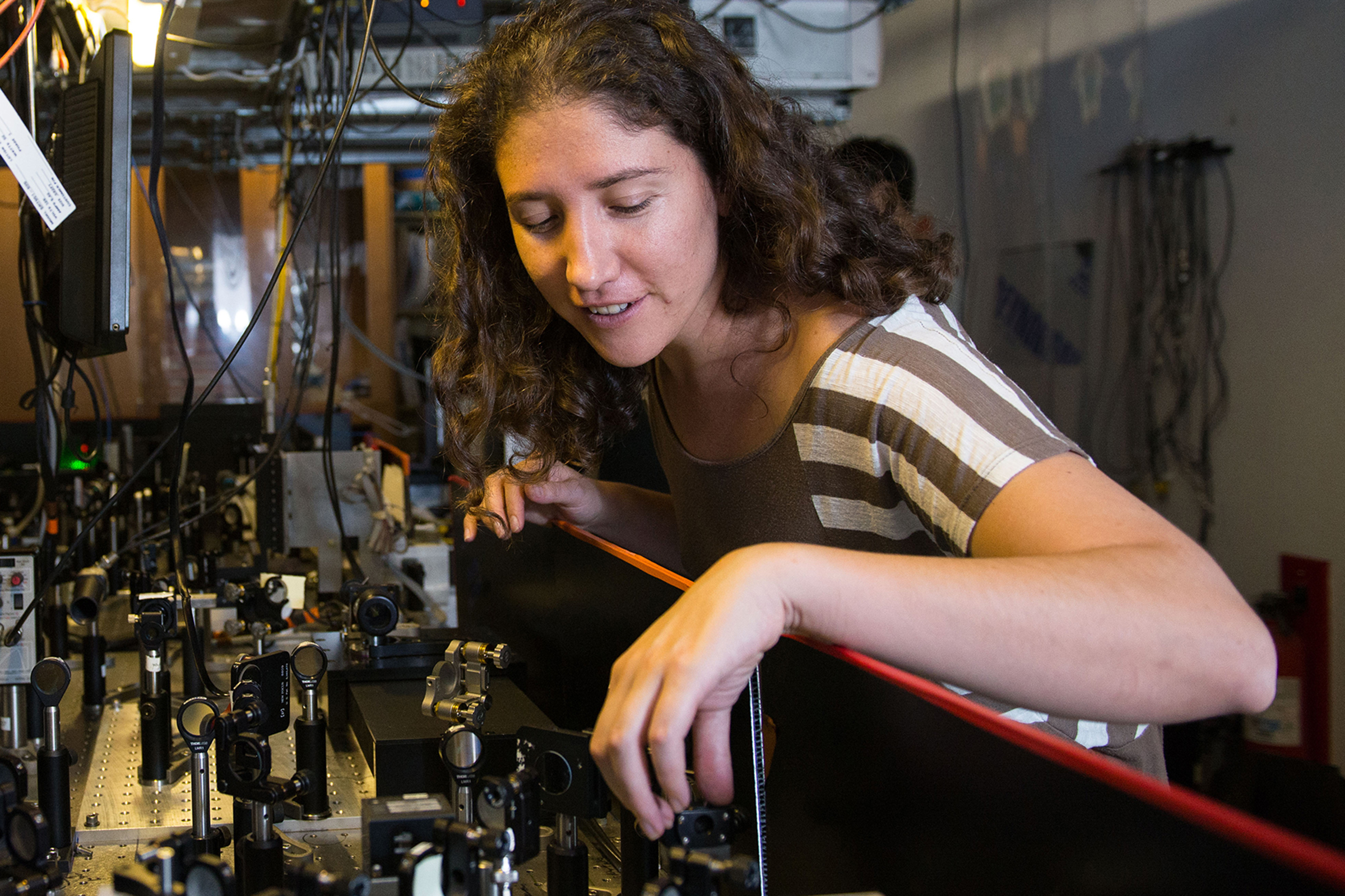 Physics graduate student adjusting laser equipment