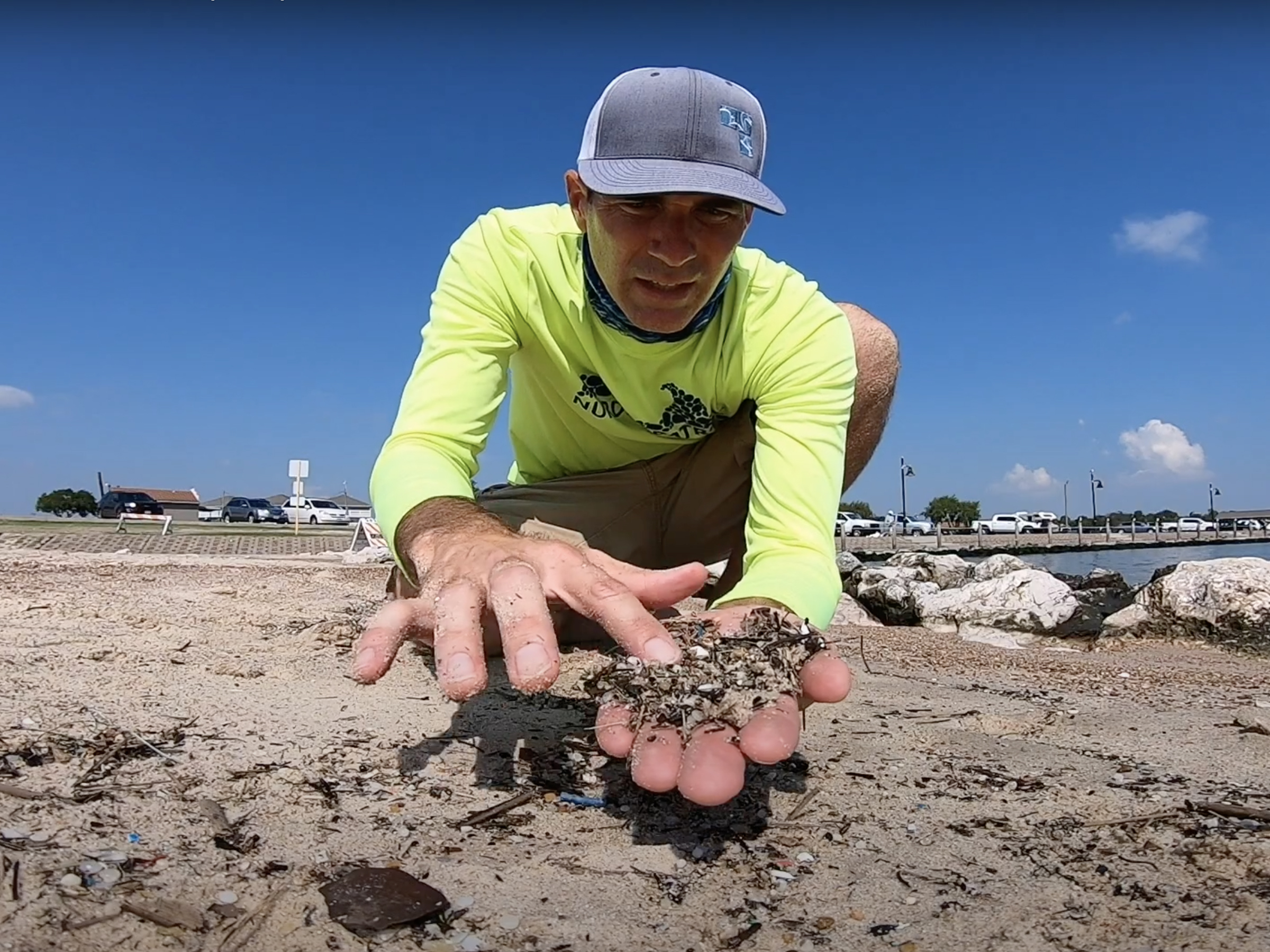 Photo of MSI research staff member holding pre-production plastic pellets found on the shore in Texas.