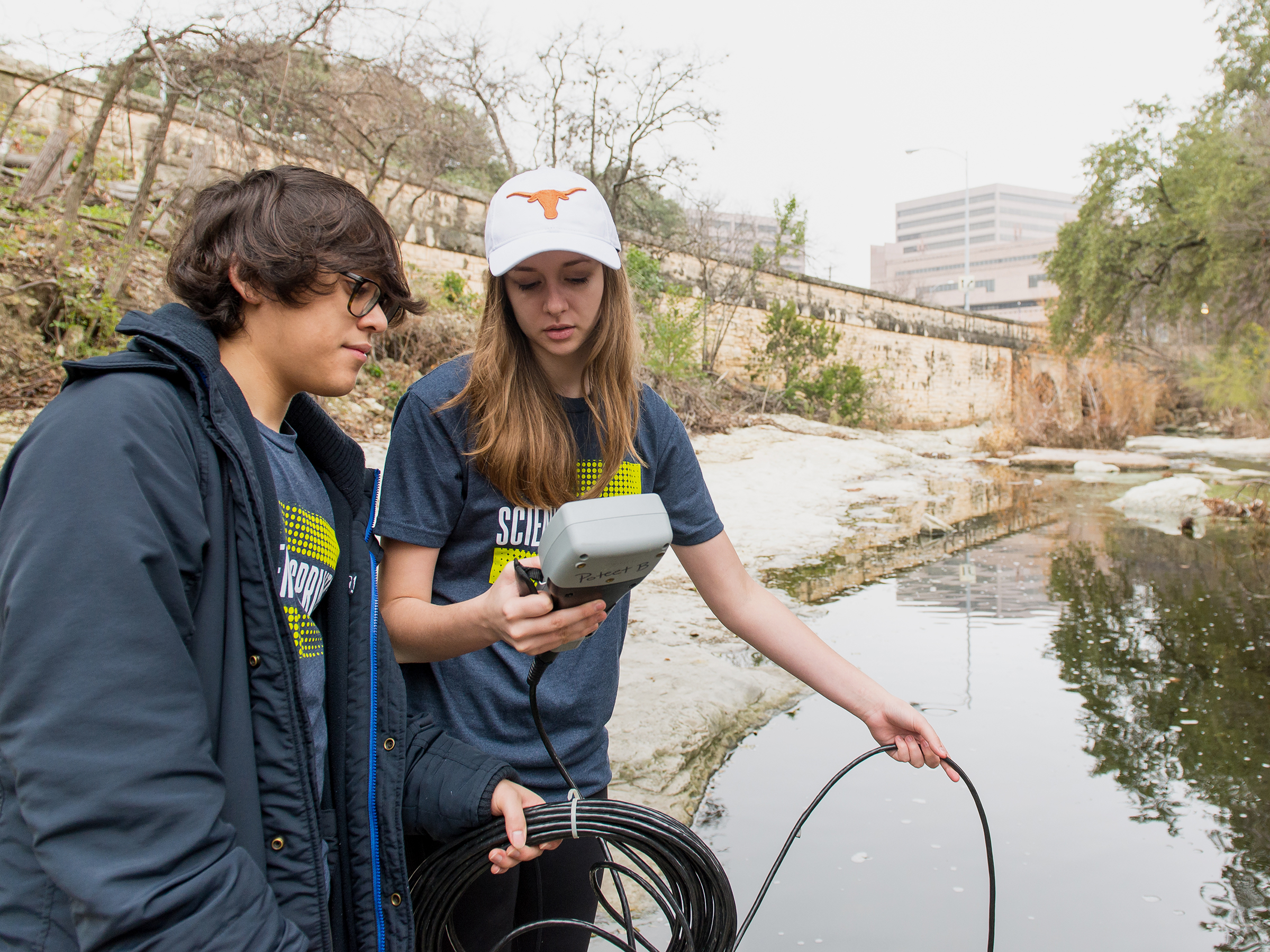 A photo of students testing water at Waller Creek as part of Science Sprints