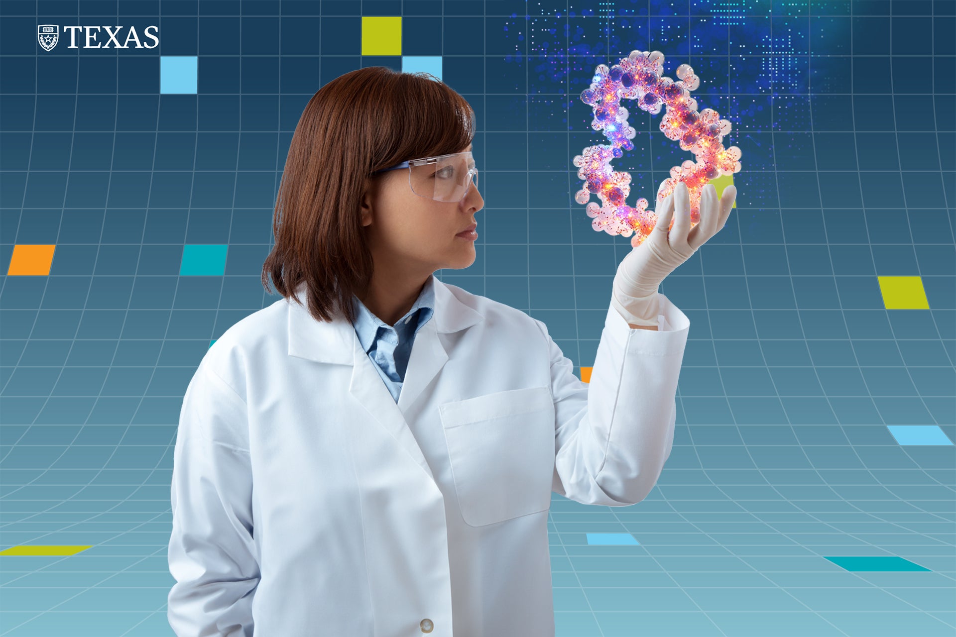 A woman in a white lab coat and gloves holds up a molecule that has been magnified to the size of her head