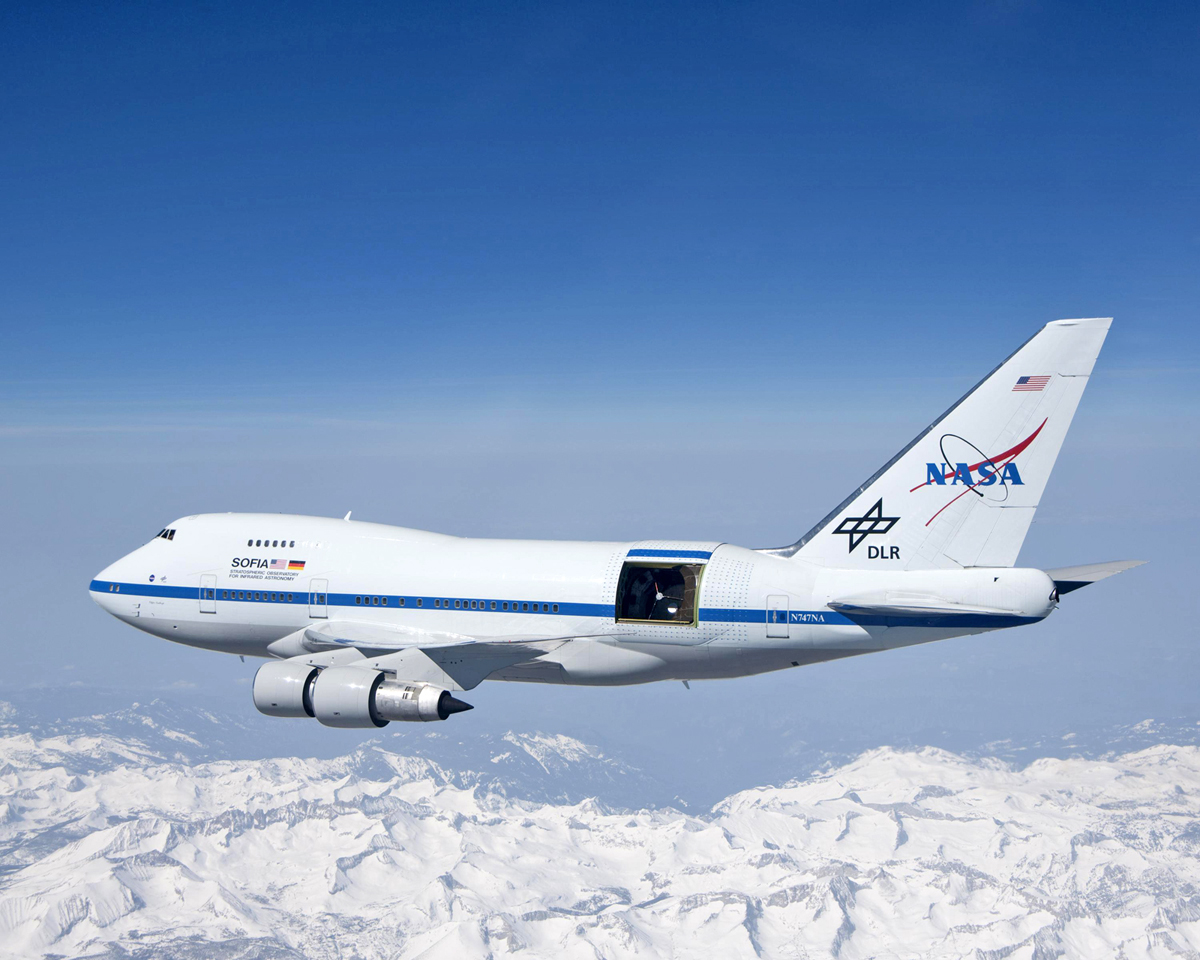 With the sliding door over its 17-ton infrared telescope wide open, NASA's SOFIA soars over California's snow-covered Southern Sierras on a test flight. Credit: NASA/Jim Ross