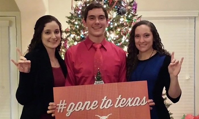Three students hold a sign that says "Gone to Texas"