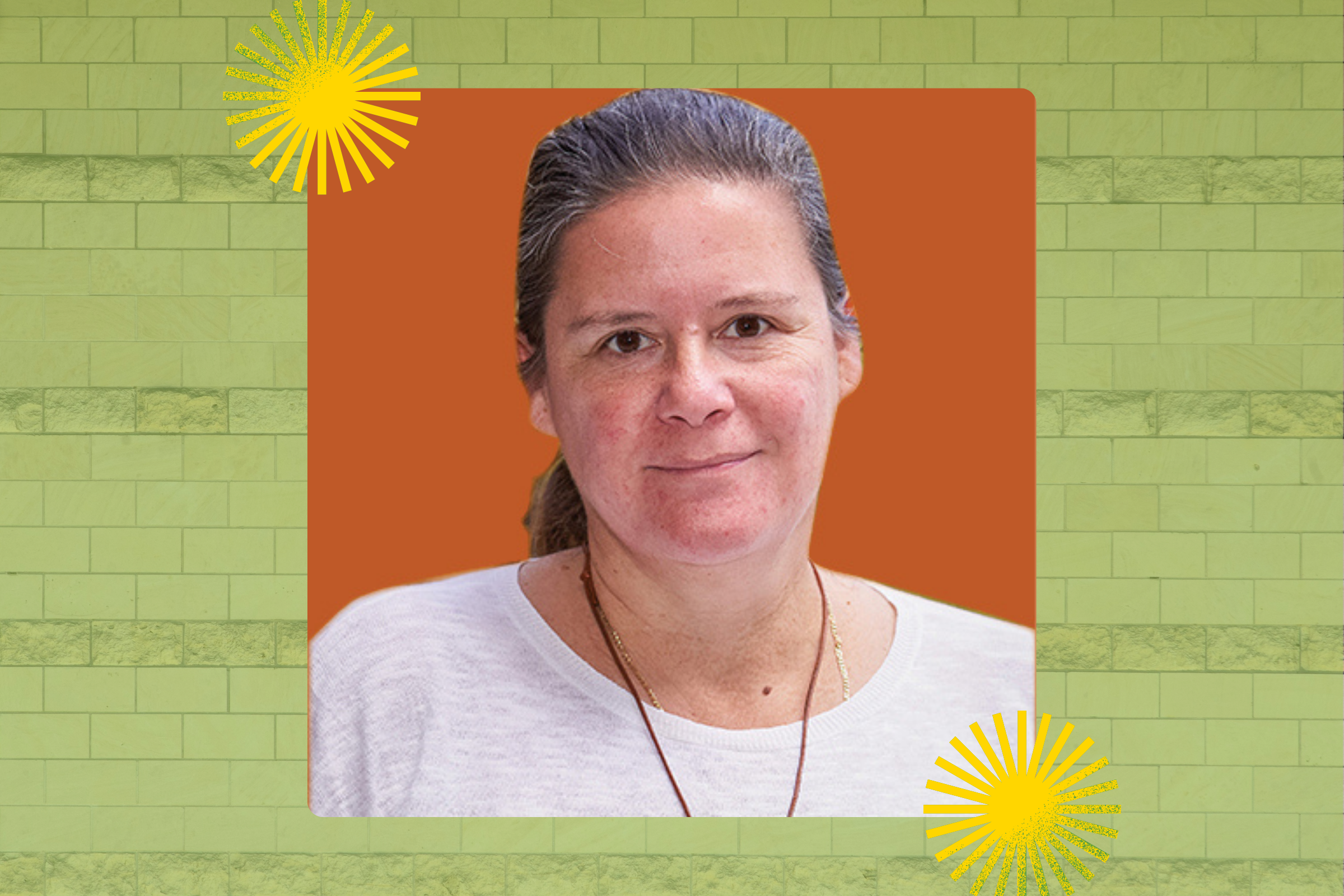 A scientist wearing a necklace smiles